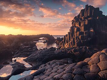 Langzeitbelichtung. Felsenstrand mit einem natürlichen Bogen bei Sonnenuntergang. Charco Azul. Insel El Hierro. Kanarische Inseln   Long exposure. rocky beach with a natural arch at sunset. Charco Azul. El Hierro island. Canary Islands