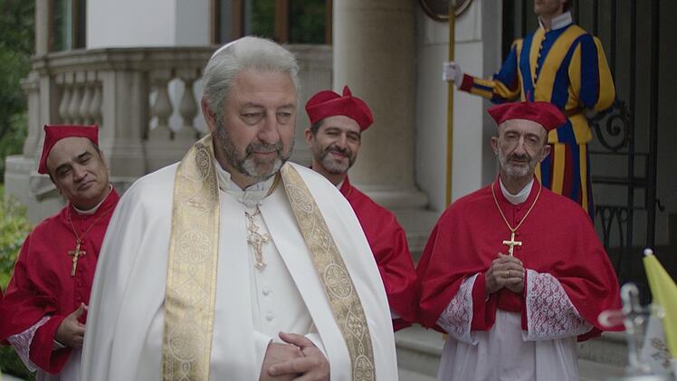 Der neue Papst (Kad Merad, Mitte) plant seine erste Reise nach S&uuml;damerika. Doch leider ist der Vatikan pleite.