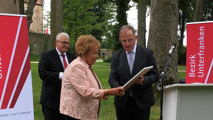 Lore Göbel empfängt den Kultur-Ehrenbrief aus den Händen von Bezirkstagspräsident Dotzel für ihr Engagement im Museum Kirchenburg Aschfeld. Foto:  Angelika Despang