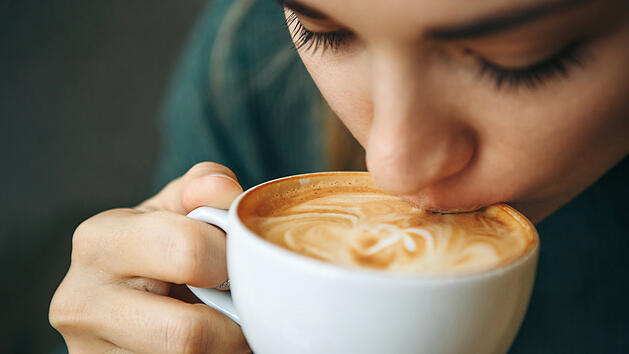 Kaffeeduft Kaffee Aroma Duft Morgen Cappuccino FlatWhite Milchschaum Crema Tasse Frau Genuss Hei&szlig;getr&auml;nk Dampf Nahaufnahme Ritual Fr&uuml;hst&uuml;ck Barista Bohnen R&ouml;stung Latte Art Espresso Alltag Hygge Zuhause W&auml;rme Entspannung Achtsamkeit Sinnesmoment Close up girl is drinking coffee. She enjoys her morning cappuccino or flat white.