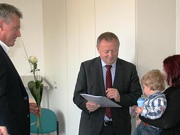 Manuela Beeson ist stolz, dass ihr Landrat Thomas Bold die Zertifizierungsurkunde überreichte, mit der sie jetzt amtlich anerkannte Tagesmutter ist. Von Jugendamtsleiter Siegbert Goll (links) bekam sie eine Rose. Foto: Werner Vogel
