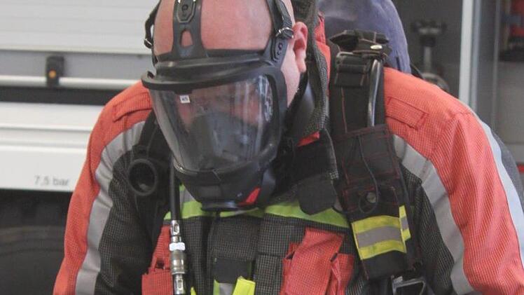 Unter der Atemschutzmaske ist der Feuerwehrmann kaum zu erkennen - und was er sagt, ist auch nicht zu verstehen. Foto: Matthias Einwag