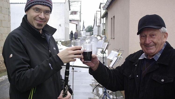 Mit einem Glühwein für alle dankt Karl Heilmann (rechts) dem Vorsitzenden der Untererthaler Musikanten, Tobias Popp, für das "Ständele".