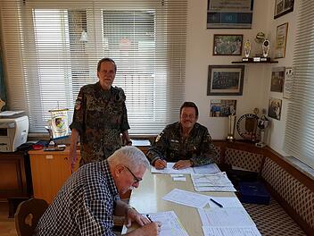 Als erster Teilnehmer trägt sich Manfred Seban (sitzend) in die Starterliste ein. Die Reservisten Wolfgang Povolny (links) und Harald Benke (rechts) überwachen den organisatorischen Ablauf. Foto: RK/Veit