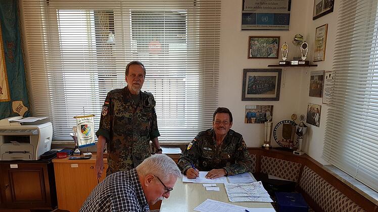 Als erster Teilnehmer trägt sich Manfred Seban (sitzend) in die Starterliste ein. Die Reservisten Wolfgang Povolny (links) und Harald Benke (rechts) überwachen den organisatorischen Ablauf. Foto: RK/Veit