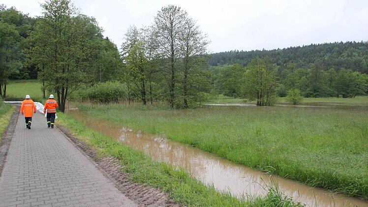 Feuerwehrleute aus Tretzendorf beobachten die Entwicklung an der Aurach.