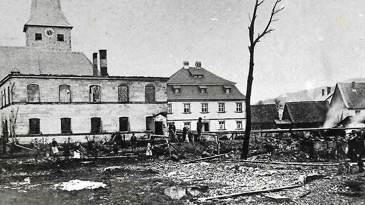Die verheerende Feuersbrunst im Jahre 1906 hatte in Neukenroth ein Bild des Schreckens hinterlassen. Links zu erkennen sind Reste des abgebrannten Schulhauses, dahinter die örtliche Kirche St. Katharina sowie das Pfarrhaus. Rechts sind ein Teil der niedergebrannten Scheunen und Nebengebäude zu sehen.  Repro Gerd Fleischmann