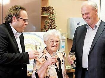 Stellvertretender Landrat Christian Pech (links) und Bürgermeister Gerald Brehm stoßen mit Erna Storner auf den 95. an. Foto: Johanna Blum
