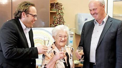 Stellvertretender Landrat Christian Pech (links) und Bürgermeister Gerald Brehm stoßen mit Erna Storner auf den 95. an. Foto: Johanna Blum
