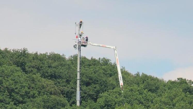 Arbeiten hoch über Ebern: Per Riesenkran lassen sich die Techniker zum Umsetzermast am Steinberg emporhieven, um den Netzausfall in den Griff zu bekommen. Foto: Eckehard Kiesewetter