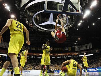 Leon Radosevic hängt nach einem Dunking am Ring - die Albatrosse sind teilweise am Boden. Der Ex-Berliner half den Bambergern mit seiner Energie, das Aufbäumen der Gastgeber im Keim zu ersticken. Fotos: Löb/dpa