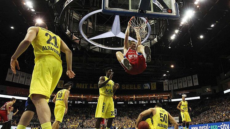 Leon Radosevic hängt nach einem Dunking am Ring - die Albatrosse sind teilweise am Boden. Der Ex-Berliner half den Bambergern mit seiner Energie, das Aufbäumen der Gastgeber im Keim zu ersticken. Fotos: Löb/dpa