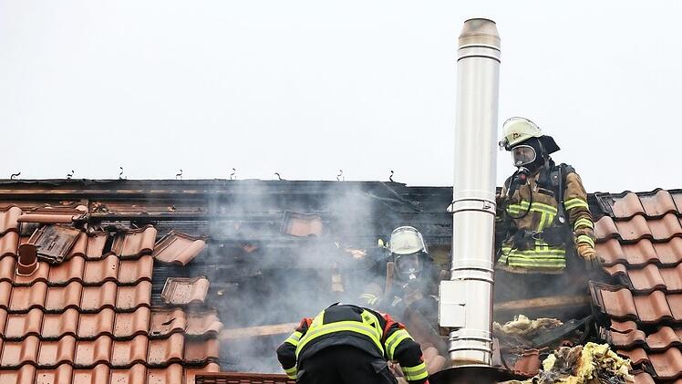 Die Feuerwehrleute entfernten einen Teil der Dachziegeln, um zum Brandnest vorzustoßen. Foto: News5/Merzbach