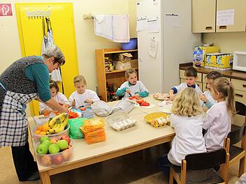 Angelika Sautter hilft den Vorschulkindern beim Zubereiten des Frühstücks im Bad Brückenauer Kindergarten Regenbogenland. Foto: Julia Raab