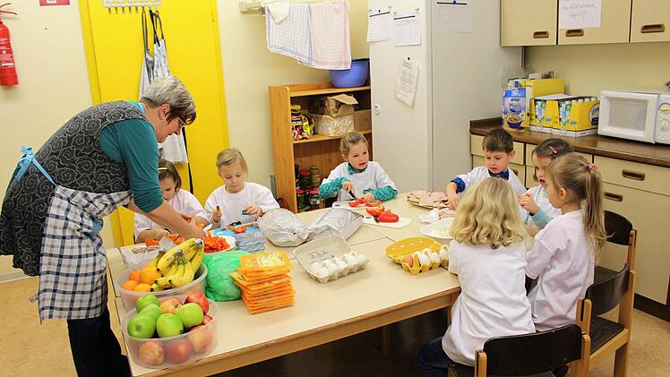 Angelika Sautter hilft den Vorschulkindern beim Zubereiten des Frühstücks im Bad Brückenauer Kindergarten Regenbogenland. Foto: Julia Raab