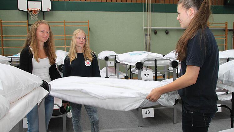 Vanessa und ihrer Schwester Lisa-Marie Zahl helfen zusammen mit Maria Stübinger (von links) i beim Bettwäsche-Beziehen.
