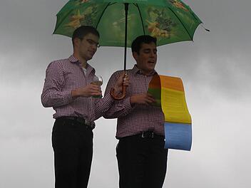 Michael Rienecker (rechts) trug in seinem Kirmesspruch manch' illustres Ereignis aus dem Oberleichtersbacher Geschehen vor, wohlbeschirmt von seinem Assistenten.Foto: Wolfgang Saam