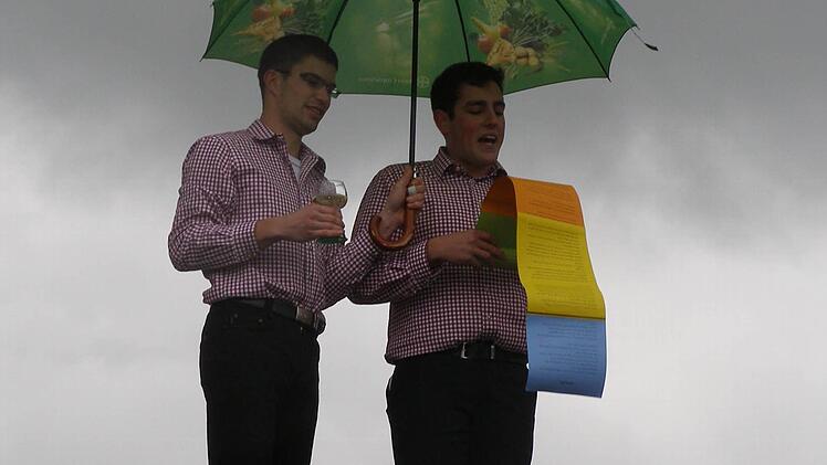 Michael Rienecker (rechts) trug in seinem Kirmesspruch manch' illustres Ereignis aus dem Oberleichtersbacher Geschehen vor, wohlbeschirmt von seinem Assistenten.Foto: Wolfgang Saam