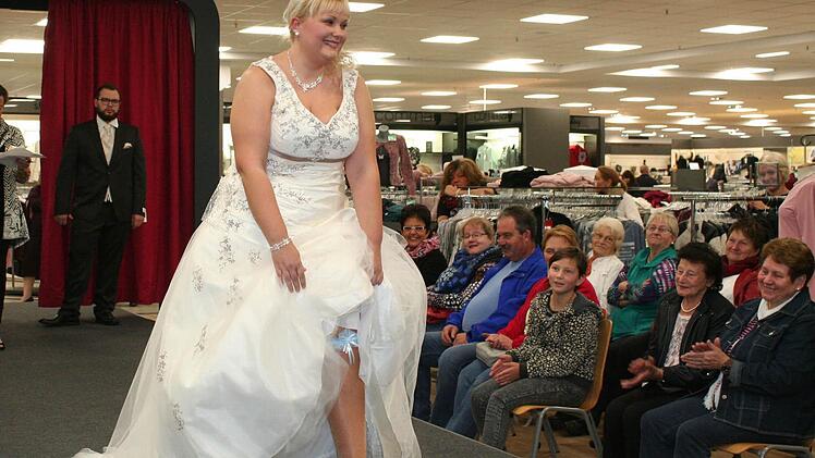 Jede Braut muss etwas Blaues tragen, zeigt kokett dieses Model im traumhaften Hochzeitskleid. Fotos: Evi Seeger