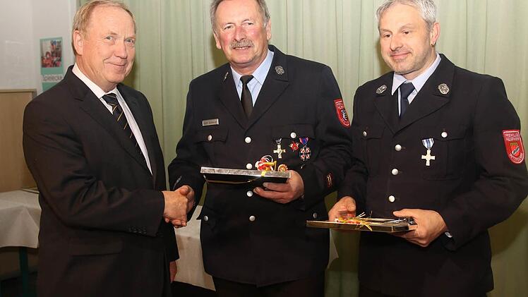 Bürgermeister Werner Thomas zeichnet die ausscheidenden Kommandanten Karl-Ludwig Schmidt und Matthias Schorn aus. Foto: Michael Stelzner