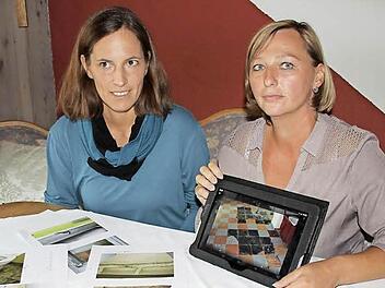 Anja Möckel (links) und Elke Frech zeigen Fotos von den baulichen Missständen an der Küpser Schule und fordern die baldige Behebung der Mängel.  Foto: Friedwald Schedel