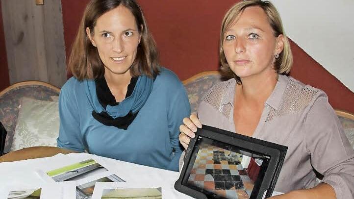 Anja Möckel (links) und Elke Frech zeigen Fotos von den baulichen Missständen an der Küpser Schule und fordern die baldige Behebung der Mängel.  Foto: Friedwald Schedel