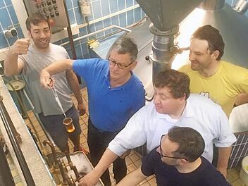 Litzendorfs Bürgermeister Wolfgang Möhrlein (im blauen T-Shirt) beim Bierbrauen in der ehemaligen Brauerei Winkler in Melkendorf. Es wird gerade vom Team um Braumeister Christian Grasser (im gelben T-Shirt) die Vorderwürze begutachtet, die vom Läuterbottich in die Kochpfanne gepumpt wird, um anschließend mit Hopfen versehen, aufgekocht wird. Foto: Andrea Spörlein