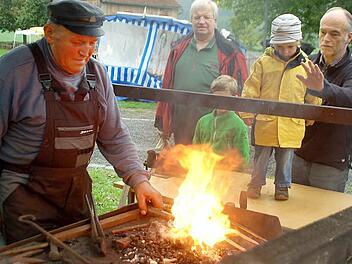 Ganz schön heiß: Adolf Herr schmiedet unter den interessierten Blicken am offenen Feuer  Fotos: Gabi Arnold
