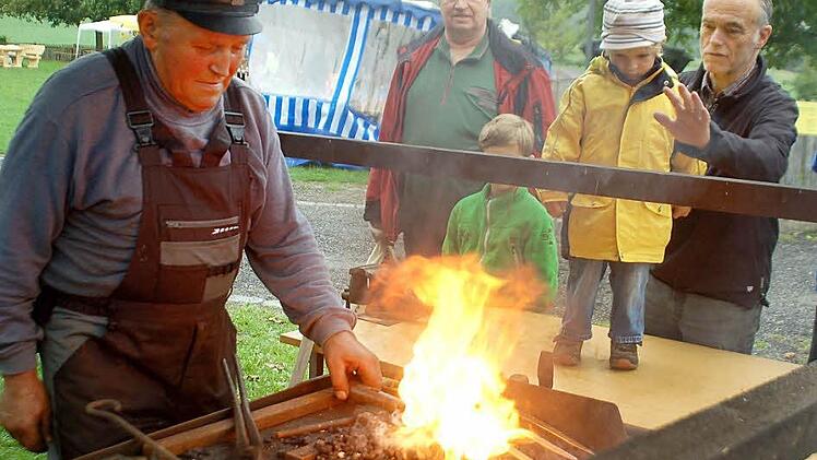 Ganz schön heiß: Adolf Herr schmiedet unter den interessierten Blicken am offenen Feuer  Fotos: Gabi Arnold