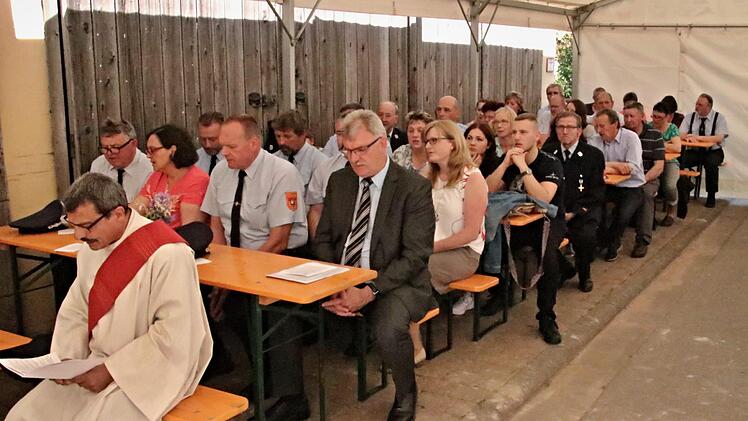 Eine der beiden Reihen mit Gästen im Festzelt beim Gottesdienst zur Segnung des neuen Feuerwehrfahrzeugs für Recheldorf. Zweite Reihe rechts: Bürgermeister Helmut Dietz und dahinter Feuerwehrreferentin Sandra Schramm.
