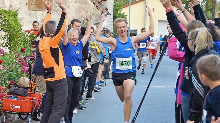 10-Kilometer-Sieger Bastian Grau wurden mit einer Laola-Welle über die Ziellinie getragen.  Fotos: Picturedreams