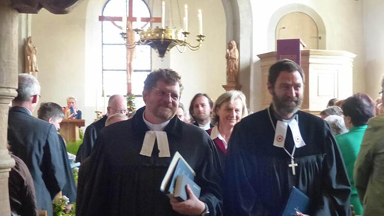 Nach dem Festgottesdienst in der Heilig-Kreuz-Kirche in Holzhausen schreiten Dekan Jürgen Blechschmidt (rechts) und der neu ins Amt eingeführte Pfarrer Mátyás Beke aus dem Gotteshaus. Foto: Manfred Wagner