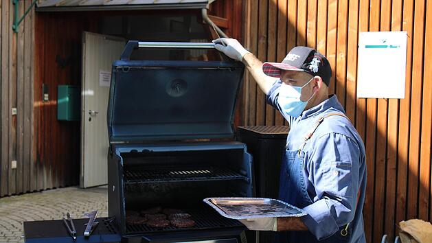 Metzgermeister Marcus Bezold k&uuml;mmert sich um das Grillgut.  Fotos: Vera Schiller