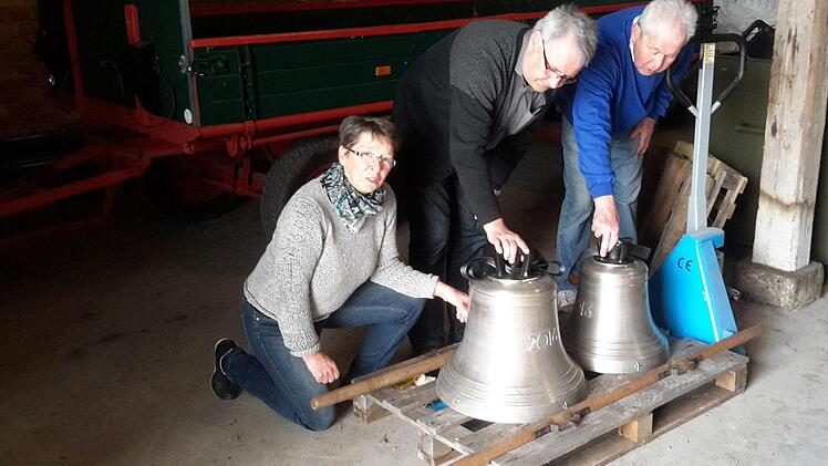 "Die haben ja ordentlich Gewicht": Erika und Reinhold Hänlein sowie Pfarrer Gerd Kirchner (Bildmitte) überzeugten sich vor der Glockenweihe schon einmal von der Qualität der beiden neuen Klangkörper für die Barockkirche in Eckarts. Foto: Rolf Pralle