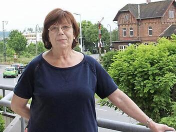 Ursula Fehling auf ihrem Balkon. Im Hintergrund rechts ist das denkmalgeschützte Creidlitzer Bahnhofsgebäude zu sehen, links der gerade mal wieder geschlossene Bahnübergang.  Foto: Simone Bastian