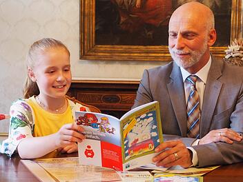 Oberbürgermeister Kay Blankenburg und die Siegerin des diesjährigen Malwettbewerbs der Stadtjugendarbeit, Nele Klauda, studieren das Ferien-Spaß-Programm der Stadtjugendarbeit. Mario Selzer