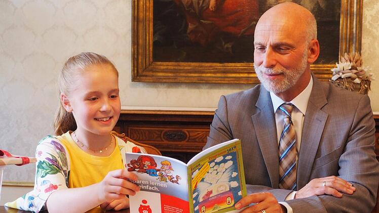 Oberbürgermeister Kay Blankenburg und die Siegerin des diesjährigen Malwettbewerbs der Stadtjugendarbeit, Nele Klauda, studieren das Ferien-Spaß-Programm der Stadtjugendarbeit. Mario Selzer