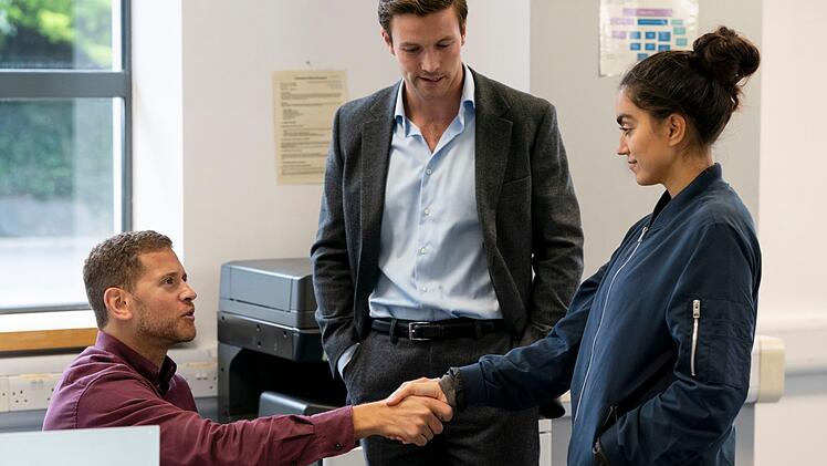 Inspector Lynley (Leo Suter, Mitte) macht Sergeant Barbara Havers (Sofia Barclay) mit dem Forensiker Simon St. James (Joshua Sher) bekannt.