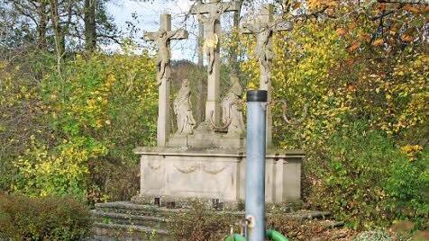 Die Kreuzigungsgruppe führt ein Schattendasein im Friedhof.