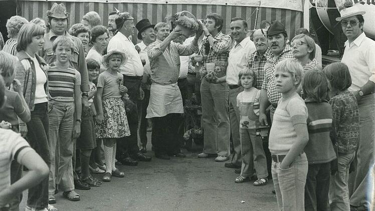 Siedlerkerwa 1977: Der unvergessene Stadtrat Reiner Baumann nimmt einen Schluck aus der Gießkanne, rechts daneben der ebenfalls verstorbene damalige SPD-Landtagsabgeordnete Heiner Stenglein.