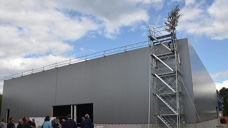 Die Gäste lauschen vor der neuen Halle dem Richtspruch von Stefan Herold.  Fotos: Bernhard Panzer