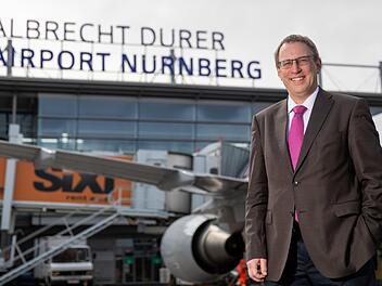 Michael Hupe, Geschäftsführer vom Albrecht Dürer Airport Nürnberg, steht am Rande der Jahres-PK auf dem Vorfeld vor dem Schriftzug des Unternehmens. Foto: Daniel Karmann/dpa