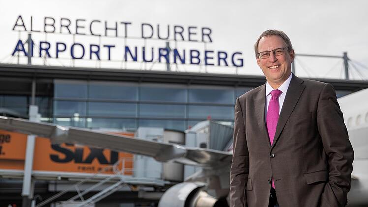 Michael Hupe, Geschäftsführer vom Albrecht Dürer Airport Nürnberg, steht am Rande der Jahres-PK auf dem Vorfeld vor dem Schriftzug des Unternehmens. Foto: Daniel Karmann/dpa