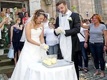Nach dem Verlassen der Kirche musste das Brautpaar zunächst fränkische Kartoffelklöße formen. Foto: Dieter Hübner