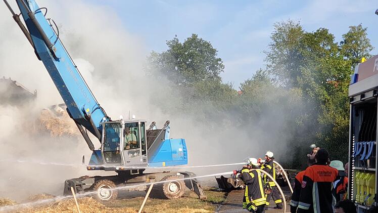 Scheunenbrand auf Bauernhof in Heilsbronn: Ein Bagger legt nach dem großen Feuer Glutnester frei. Foto: NEWS5 / Fechner