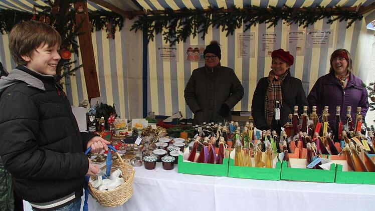 Yannick Wunder verkauft gebrannte Mandeln - der Erlös kommt der Sanierung der Traischel-Kapelle zugute. Die Frauenunion bietet unterdessen Leckereien aus dem Hause von Lerchenfeld und selbstgemachte Liköre an.