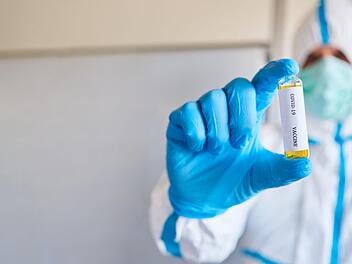 Forscher in Schutzkleidung mit Coronavirus Impfstoff Test mit Antikörpern im Labor gegen Covid-19 Krankheit. Foto: Adobestock