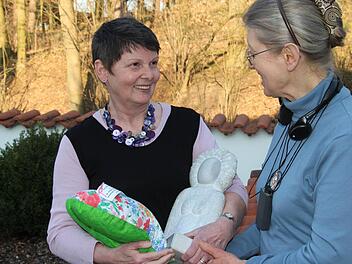 Doris Wienke (links) im Gespräch mit Cecilia Trautner. In der einen Hand hält sie die steinerne "Bürgerwilma", in der anderen eines ihrer gequilteten Herzkissen.  Foto: Christian Bauriedel
