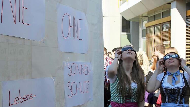In der Q12 am Ehrenbürg-Gymnasium war Dirndl-Tag für (v.l.) Leni Fliehr und Katharina Dehm. Im Schulgarten betrachten die beiden, wie der Mond die Sonne verdeckt.  Foto: Michael Memmel