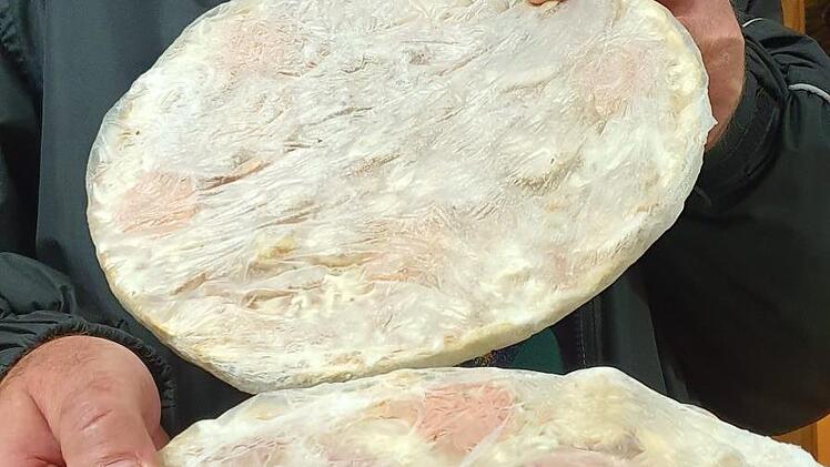 Eduard Schmittlutz zeigt Tiefkühlpizza. Palettenware, die die Tafeln verteilen dürfen.